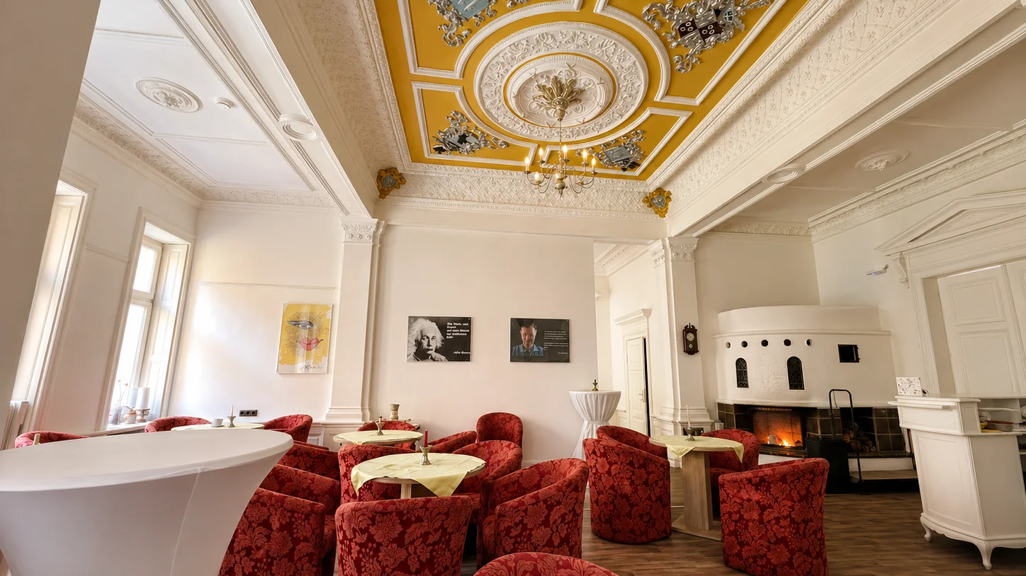 Rittersaal im Schloss Groß Potrems mit historischer Stuckdecke und offenem Kamin